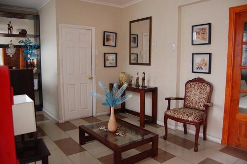 - un salon avec un vase sur une table et une chaise dans l'établissement Andina Hostel, à Iquique