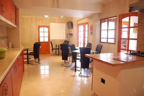 - une cuisine avec des chaises et une table dans une pièce dans l'établissement Andina Hostel, à Iquique