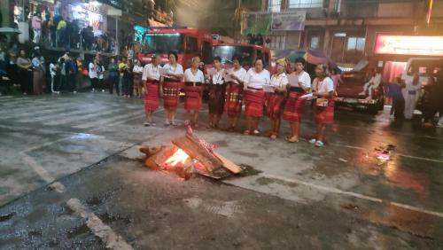 a group of girls standing around a fire in the street at Banaue Sunrise Guest House in Banaue