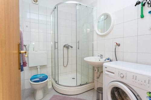 een badkamer met een douche, een toilet en een wastafel bij Apartments with a parking space Cove Smrceva, Brac - 20193 in Milna