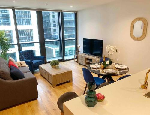 een woonkamer met een bank en een tafel bij So Unique! Collins Street Vibe 2B2B in Melbourne
