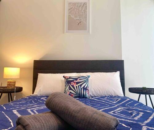 a bed with a blue comforter and a pillow on it at So Unique! Collins Street Vibe 2B2B in Melbourne