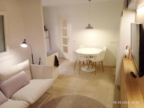 a living room with a white couch and a table at Newly renovated 2 bed apartment in Blanes old town 50m from the beach! in Blanes