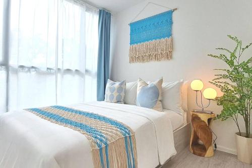 ein Schlafzimmer mit einem weißen Bett und einer Topfpflanze in der Unterkunft SEA BREEZE VIBE @ ATMOZ BANGNA (Si Iam MRT.) in Ban Khlong Samrong