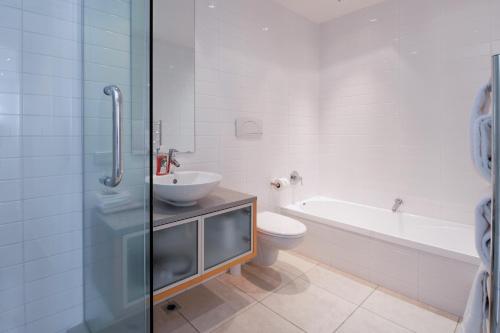 La salle de bains est pourvue d'un lavabo, de toilettes et d'une baignoire. dans l'établissement Waimahana Apartment 8, à Taupo