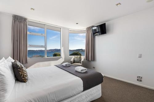 a bedroom with a bed and a large window at Waimahana Apartment 8 in Taupo