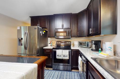 a kitchen with wooden cabinets and stainless steel appliances at Seven Rings in Dauphin Island