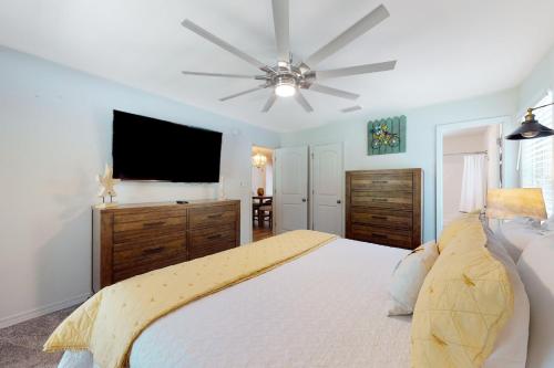 a bedroom with a large bed with a ceiling fan at Seven Rings in Dauphin Island