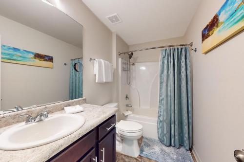 a bathroom with a sink and a toilet and a shower at Seven Rings in Dauphin Island