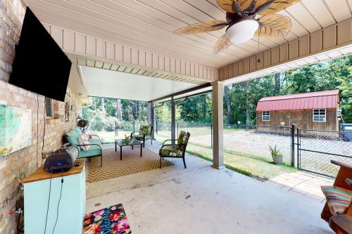 a living room with a ceiling fan and a person sitting on a couch at Seven Rings in Dauphin Island