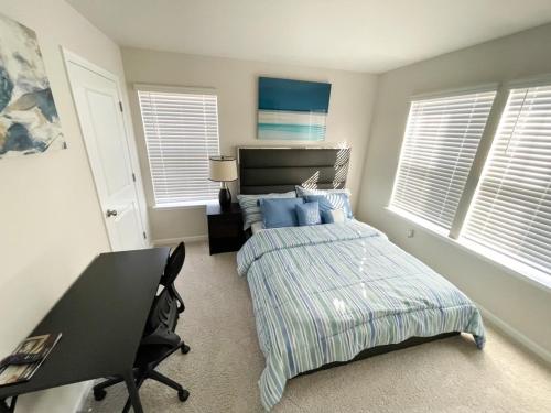 a bedroom with a bed and a desk and windows at Ruby Home in Bowie