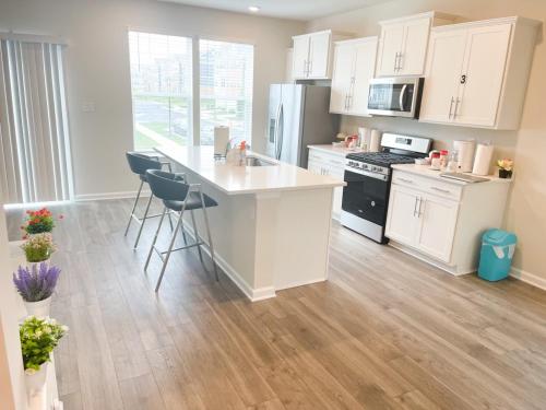 a kitchen with white cabinets and a kitchen island with stools at Ruby Home in Bowie