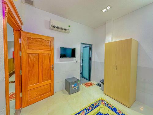 a room with a wooden door and a television in it at NHÂN TÂY 2 HOTELs in Can Tho
