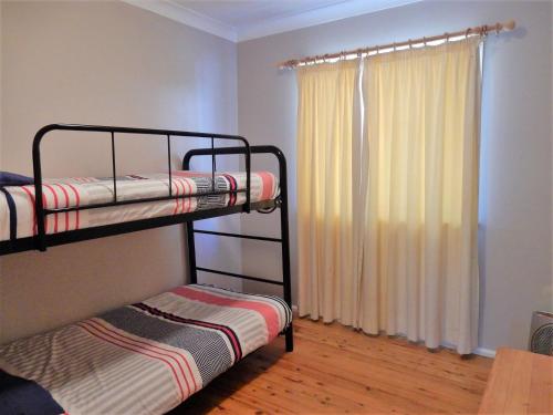 a bedroom with two bunk beds and a window at Donlan's Delight in Mollymook