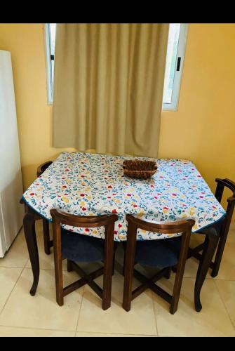 uma mesa com uma toalha de mesa estampada com flores e duas cadeiras em La escondida em Mercedes