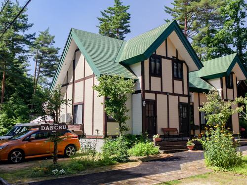 a house with a car parked in front of it at Landhaus Dancru Netz in Hakuba