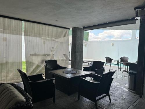 a room with a table and chairs and a balcony at Residencia en Apodaca Nuevo León in Monterrey
