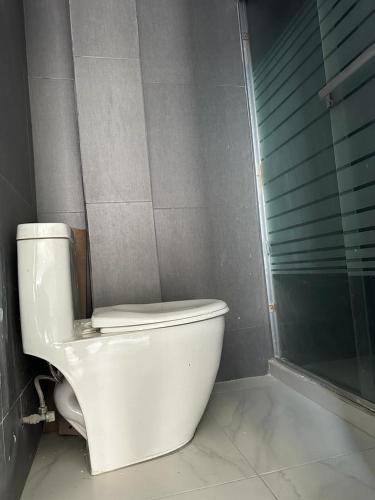 a white toilet in a bathroom with a shower at Residencia en Apodaca Nuevo León in Monterrey