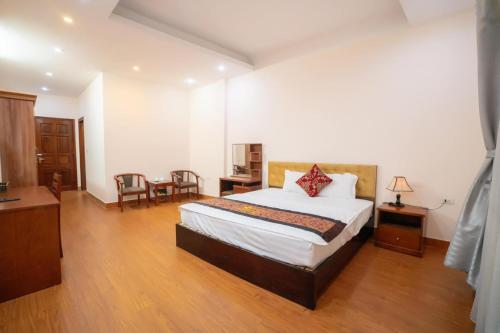 Schlafzimmer mit einem Bett, einem Tisch und Stühlen in der Unterkunft Hoang Yen Hotel - Gần đại học Sư Phạm TN in Thái Nguyên