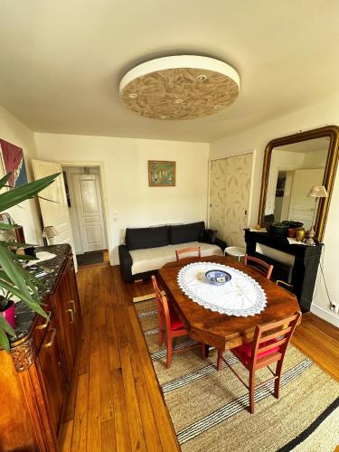 un salon avec une table et un canapé dans l'établissement Appartement SAINTE ELISABETH - République, à Paris