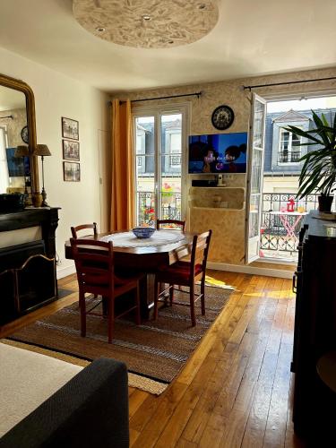 une salle à manger avec une table et des chaises dans une pièce dans l'établissement Appartement SAINTE ELISABETH - République, à Paris