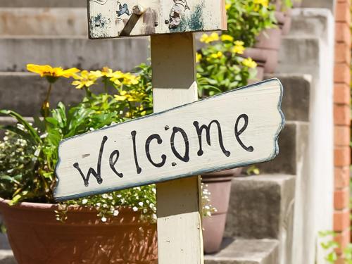a sign that says welcome in front of some plants at Landhaus Dancru Netz in Hakuba