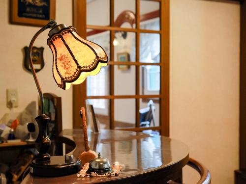 a lamp sitting on top of a wooden table at Landhaus Dancru Netz in Hakuba