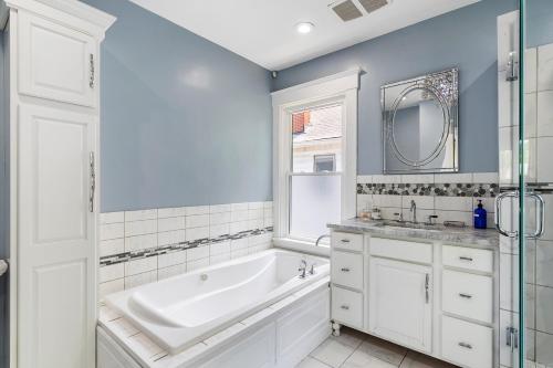 a bathroom with a tub and a sink and a mirror at Modern Oakley Retreat - King Bed - Free Parking - Centrally Located in Cincinnati
