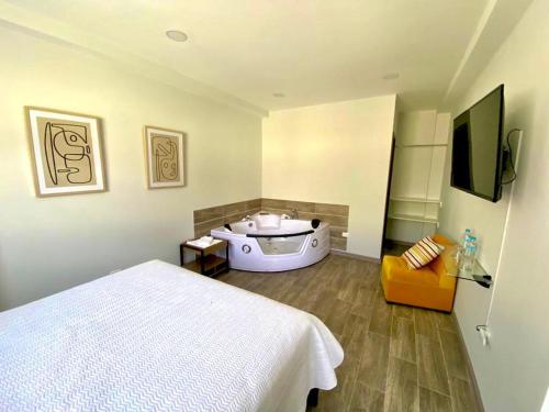 a bedroom with a bed and a bath tub at SUITE DE LUX in Baños