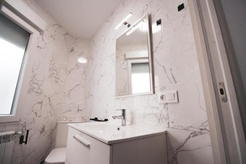 Baño blanco con lavabo y espejo en LOS PLÁTANOS - Riópar, en Riópar