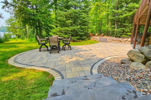 a patio with a table and chairs in a yard at Annabelle Log Home in Presque Isle