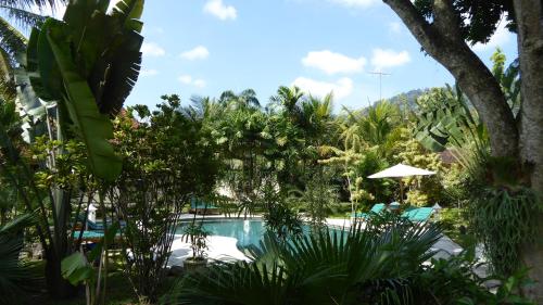 a pool in the middle of a resort with trees at Rumah Kita Villa/hotel in Kalibaru