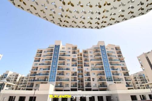 a large apartment building with a bunch ofoths on it at Down town new El alamein in El Alamein