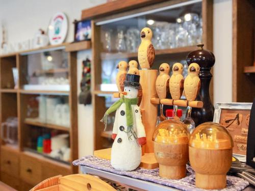 a group of wooden figurines of birds on a counter at Landhaus Dancru Netz in Hakuba