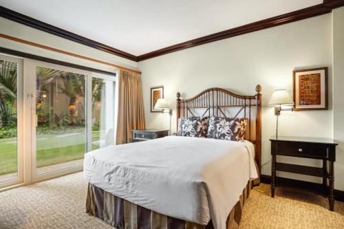 a bedroom with a large bed and a large window at Condos in Waipouli Beach Resort in Kapaa