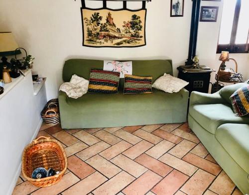 a living room with a green couch and a basket at Cortile Padre Vincenzo in Erice
