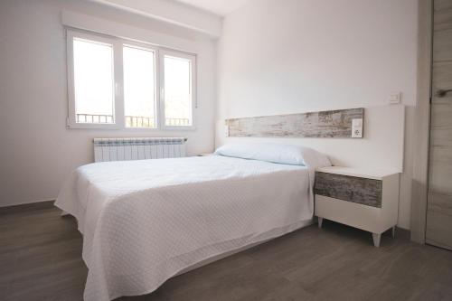 1 dormitorio blanco con 1 cama grande y 2 ventanas en LOS PLÁTANOS - Riópar, en Riópar