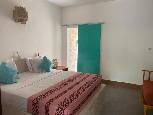 - une chambre avec un grand lit et une porte verte dans l'établissement The Barefoot Blondie Village, à Gili Air