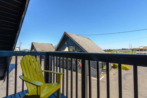 a green chair sitting on the balcony of a house at Tidal House 2 in Ocean Shores