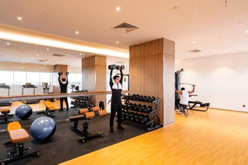a man standing in a gym with weights at Holiday Inn Sepang - Airport in Sepang