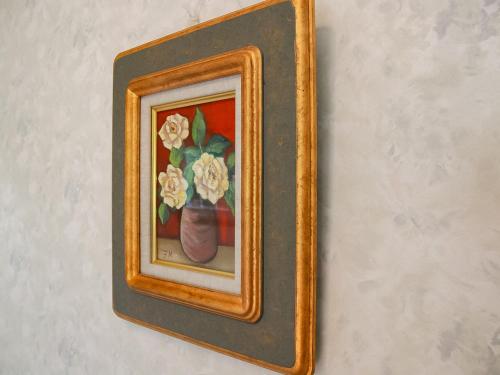 a picture of a vase with flowers on a wall at Landhaus Dancru Netz in Hakuba