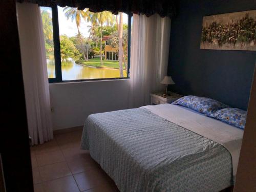 a bedroom with a bed and a large window at Casa en Caribbean con Wifi in Tucacas