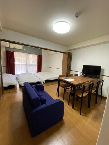 a living room with a blue couch and a table at Laforet Tokaichi in Hiroshima