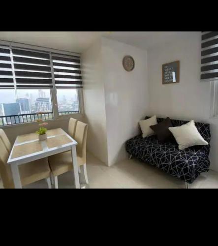 una pequeña sala de estar con mesa y sofá en Calyx Residences, 18H, en Cebú