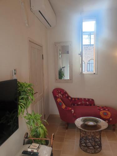 uma sala de estar com um sofá vermelho e uma mesa em Luxury studio at the heart of old Jaffa em Tel Aviv