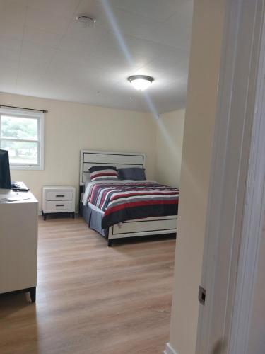 Schlafzimmer mit einem Bett, einem Schreibtisch und einem Fenster in der Unterkunft Rustic Redlion Home 