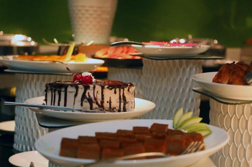 a table with plates of chocolate cake and other desserts at Grand Serendib Hotel in Kandy