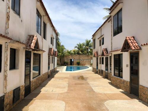 an alleyway between two buildings with a swimming pool at Casa frente a la playa con wifi in Tucacas