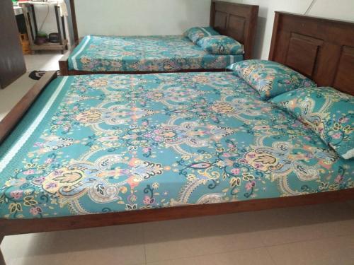 una camera con due letti e un piumone blu di Sensitha Holiday home a Anuradhapura
