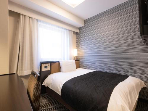 1 dormitorio con 1 cama y ventana grande en APA Hotel Ginza Shintomicho Ekimae Kita, en Tokio